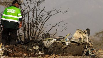 Un agente de polic�a se encuentra junto a los restos de la peque�a aeronave involucrada en un accidente fatal que cost� la vida a sus 13 ocupantes en el distrito de Vista Alegre, Nazca, Per�.