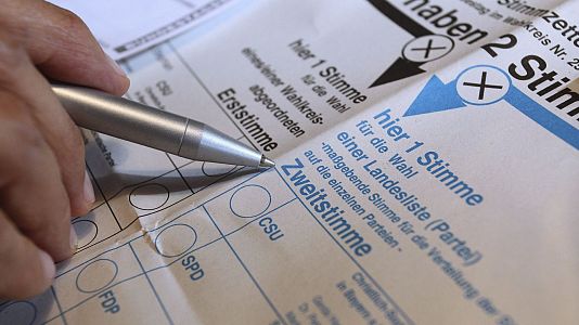 Un ciudadano alem�n cumplimenta una papeleta electoral de voto