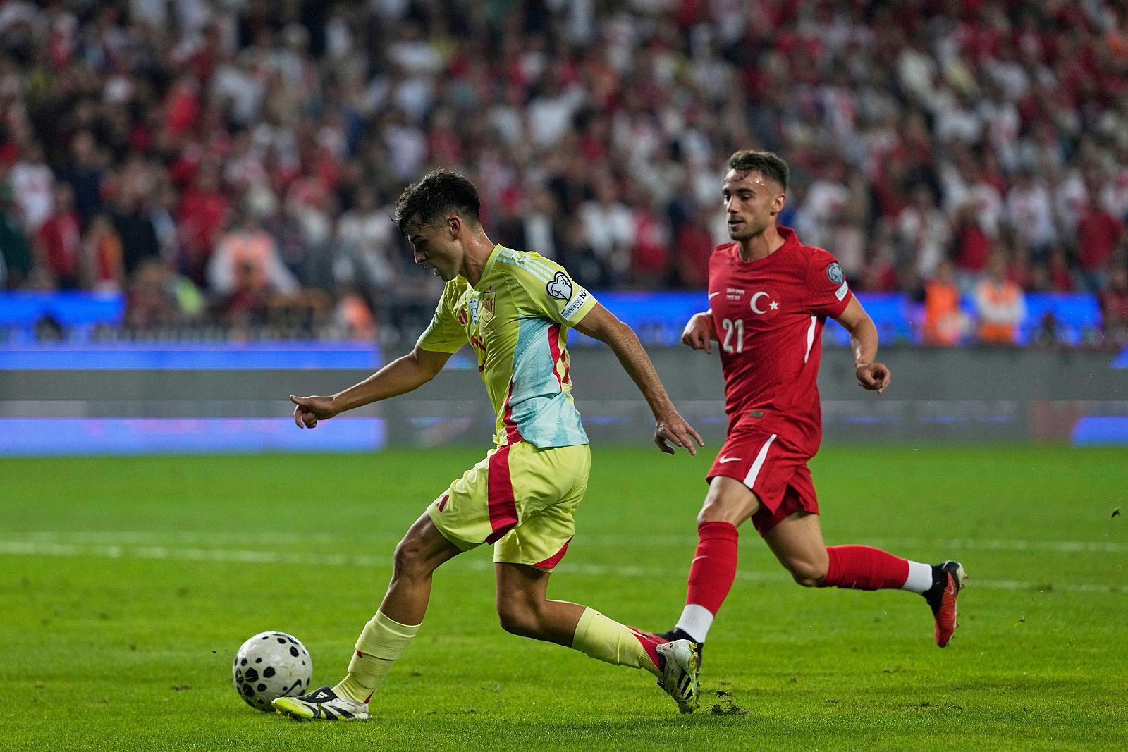 Spain's Pedri, left, passes the ball followed by Turkey's Yunus Akgun during a World Cup qualifying round Group E soccer match between Turkey and Spain at Konya Buyuksehir stadium, in Konya, Turkey, Sunday, Sept. 7, 2025. (AP Photo/Khalil Hamra)