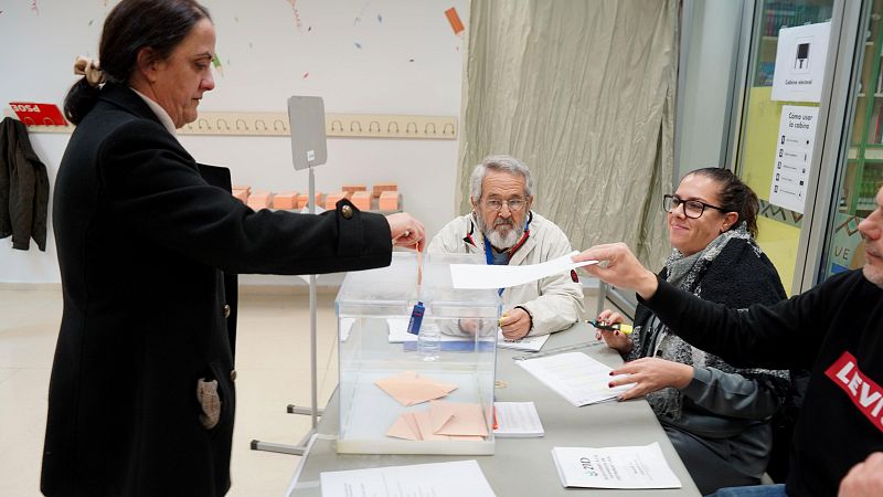 Una mujer vota en una mesa electoral en un colegio en Plasencia