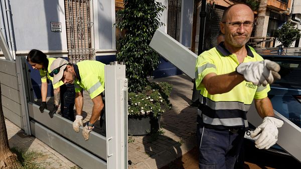 Varios operarios instalan una barrera para contener el agua en el barranco de la Saleta de Aldaia, en Valencia