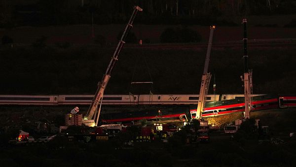 Gr�as elevan vagones de tren siniestrados mientras los equipos de rescate buscan v�ctimas tras una colisi�n entre dos trenes en Urda