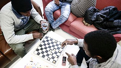 Dos refugiados pasan el rato en el centro de d�a de Pantin, en Par�s