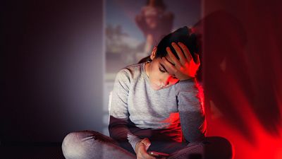 Una mujer joven observa preocupada una fotografa en su mvil