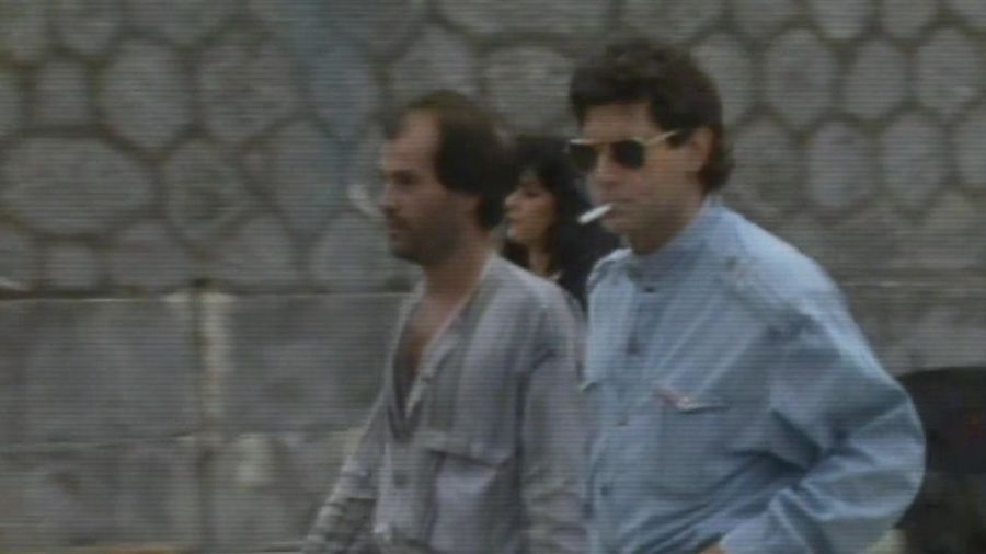 Jesús Quintero y Rafi Escobedo caminando, con un muro de piedra al fondo.
