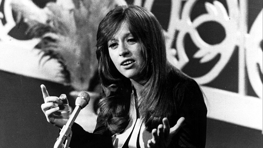 Mari Trini, cantante española, hablando por un micrófono en una foto en blanco y negro de 1969.  Gesticula con las manos.