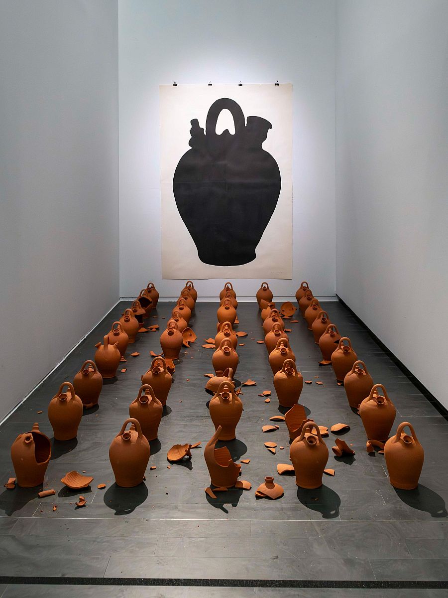Instalación "Damocles" (2017): vasija grande en la pared y vasijas de terracota, algunas rotas, en el suelo.  Fragilidad y precariedad.