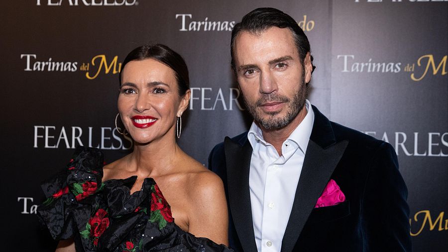 Arantxa del Sol, con vestido negro y pendientes grandes, y Finito de Córdoba, con traje oscuro y pañuelo fucsia, posan en un evento con fondo promocional que incluye las inscripciones "Tarimas del Mundo" y "Fearless".