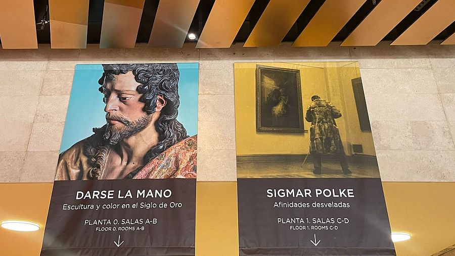 Carteles del Museo del Prado anuncian las exposiciones "Darse la mano" (escultura, Siglo de Oro) y "Sigmar Polke" (fotografía), indicando sus ubicaciones.