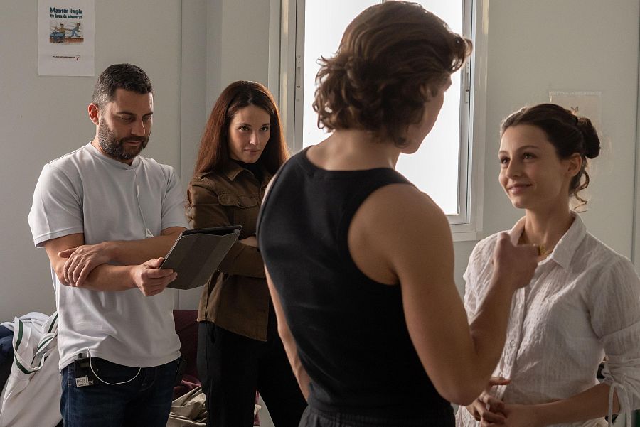Ensayo de cuatro personas: dos observan mientras otros dos ensayan una escena.  Ambiente de trabajo y concentración.
