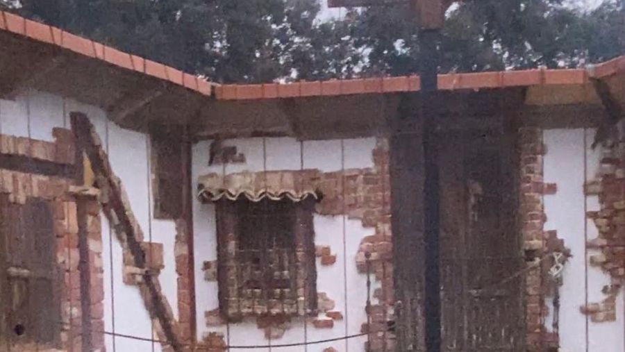 Edificio de ladrillo con tejas rojas y ventana enrejada.  Se leen las inscripciones "GREFA - Primillar" y "Aquí la Tierra".