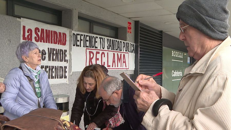 Recogida de firmas en un hospital para defender la sanidad pública.  Carteles con lemas reclamando la defensa de la sanidad pública y personas firmando documentos.