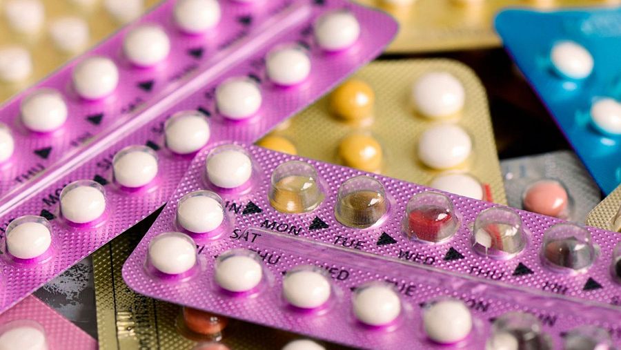 Diversos blísteres de pastillas anticonceptivas de colores variados, con pastillas blancas y de colores. Algunos blísteres indican los días de la semana en inglés.