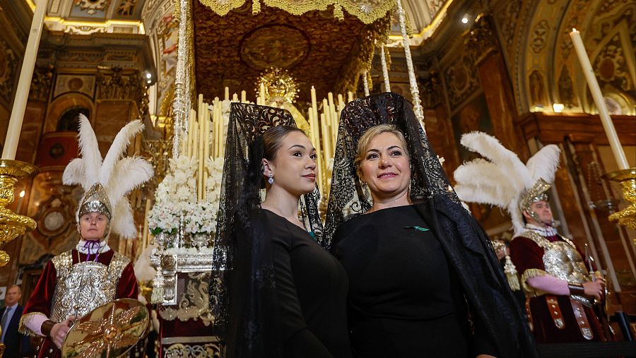 Mujeres de mantilla posan ante la Virgen de la Macarena este Jueves Santo