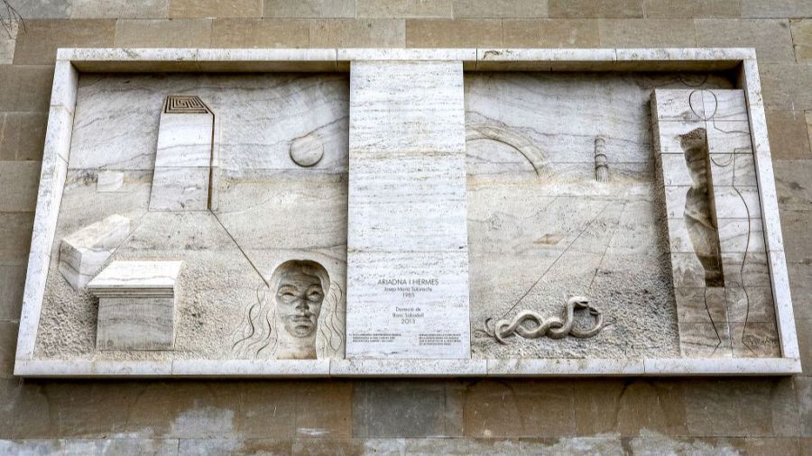Relieve abstracto de 1985, con figuras de Ariadna y Hermes, elementos geométricos y un título en placa central. Donado en 2013.