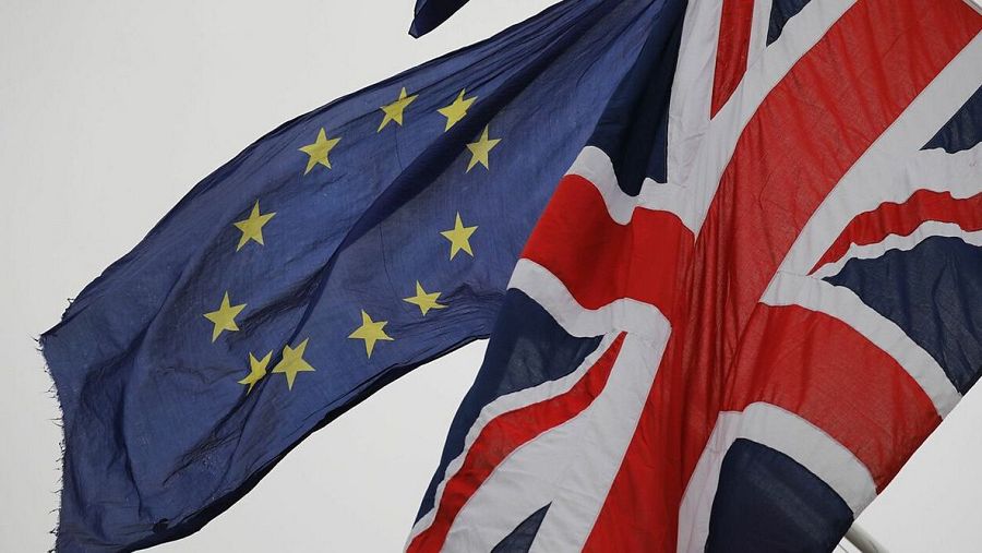 Banderas de la UE y el Reino Unido ondeando juntas, posiblemente simbolizando la relación pre o post-Brexit.
