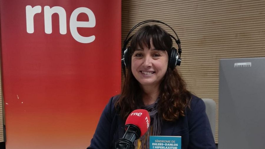 Presentadora de RNE en estudio de radio, con auriculares, hablando a micrófono sobre "Síndrome de Ehlers-Danlos e Hiperlaxitud".