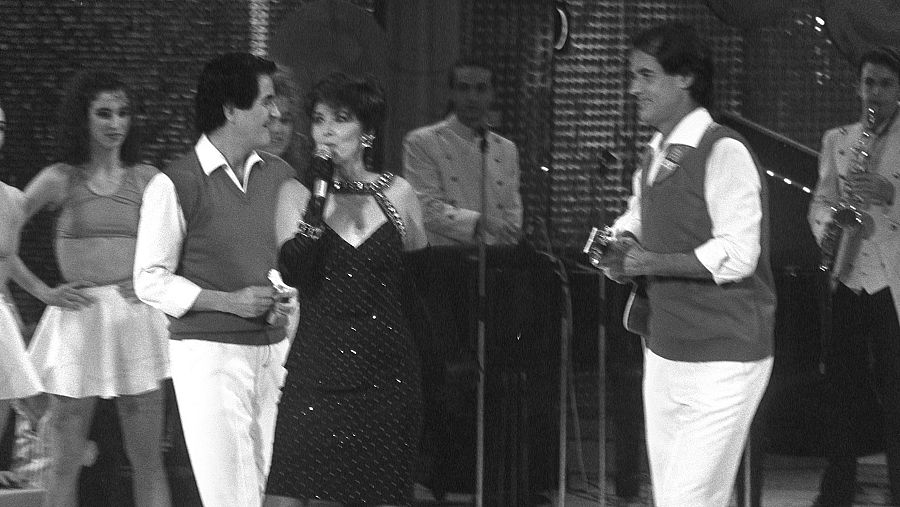 Concha Velasco (c), presentadora del programa "Viva el espectáculo", interpreta una de las canciones del "Dúo Dinámico", compuesto por Manuel de la Calva (izq) y Ramón Arcusa (dcha).