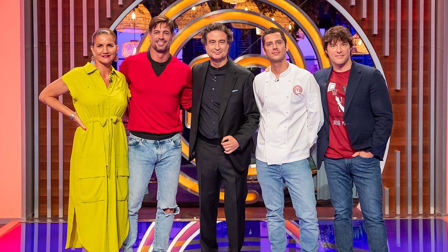 En un estudio televisivo, un grupo de cinco personas posan. Destacan un hombre con chaqueta de chef y otro con camiseta roja, ambos rodeados por el logo de un programa culinario.