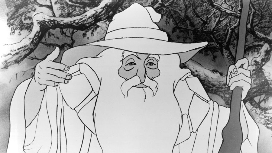 En una ilustración en blanco y negro, se observa a un personaje con sombrero y larga barba, vestido con una túnica y sosteniendo un bastón. El fondo muestra árboles.