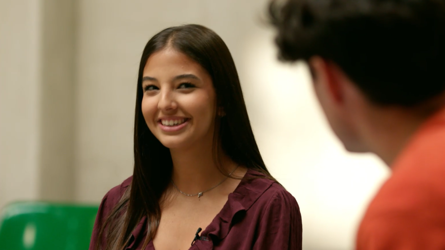 En la imagen, una joven sonriente con blusa burdeos y collar observa a un joven de espaldas con camiseta naranja, con un texto en la parte superior sobre la inteligencia artificial y la terapia.