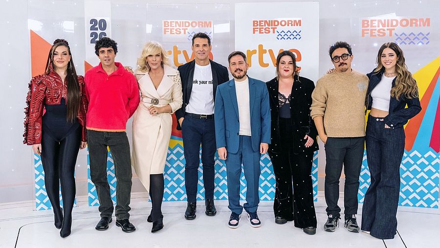Ocho personas posan para una foto frente a un fondo con logos y el número "2024". Los individuos visten ropa variada, incluyendo conjuntos rojos, abrigos y trajes, en un evento presentado por RTVE.
