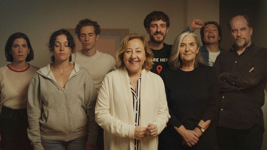 Un grupo de ocho personas posan juntas, con una variedad de estilos y edades. Se distinguen mujeres con el pelo corto y hombres con barba, vistiendo ropa casual como camisetas, sudaderas y camisas.