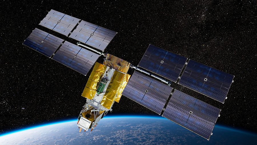 Un satélite con paneles solares azules y cuerpo dorado orbita sobre una representación de la Tierra, rodeado de estrellas brillantes en un entorno espacial.