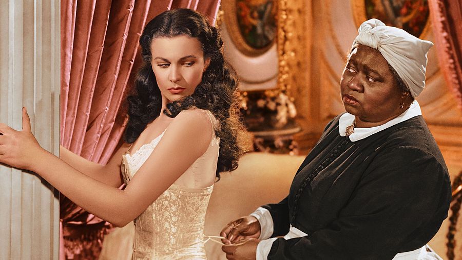 Vivien Leigh, como Scarlett O’Hara, mientras Hattie McDaniel, en el papel de Mammy, le ajusta el corsé en una escena de Lo que el viento se llevó (1939)..