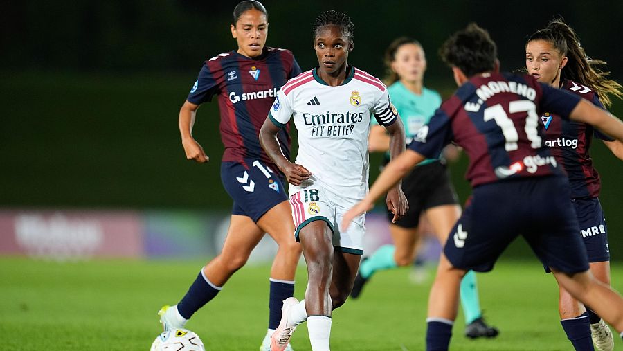 Caroline Weir (Real Madrid, 18) conduce el balón, perseguida por jugadoras del Eibar, incluyendo Eider Moreno (17), en un partido nocturno.
