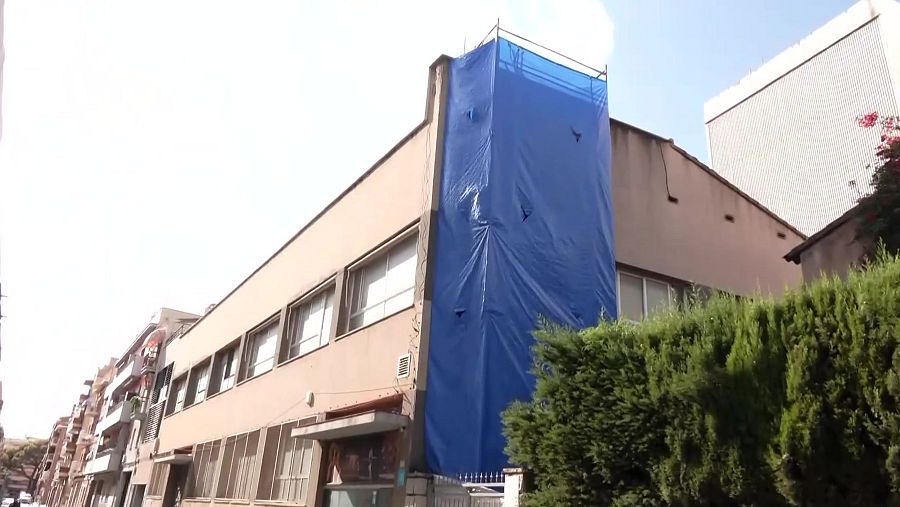 Imatge de la façana en què s'estan fent les actuacions, tapada per una lona blava.