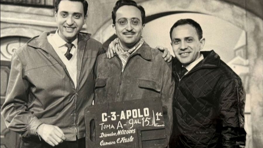 Los hermanos Antonio, Mariano y José Luis Ozores posan sonrientes y abrazados en un plató de cine junto a una claqueta.