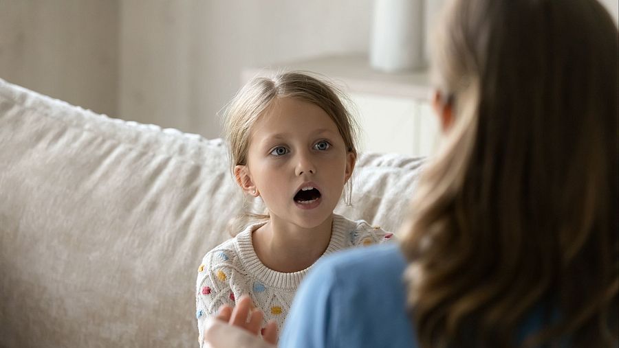 Una niña practica ejercicios de vocalización y respiración durante una sesión de logopedia infantil.