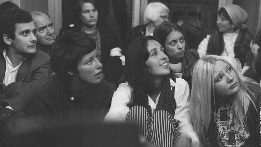 Fotografía en blanco y negro de un grupo de manifestantes sentados en el interior de un edificio durante una protesta contra el reclutamiento militar en 1967.