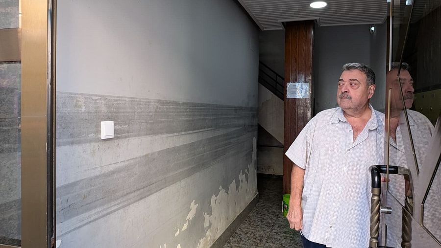Àngel, vecino de la calle Gómez Ferrer de Alfafar, muestra hasta dónde llegó el agua en su portal
