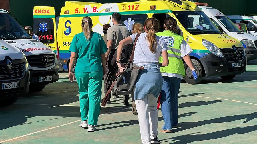 Médicos y enfermeros acceden al polideportivo de Urda para atender a los heridos, con varias ambulancias como apoyo.