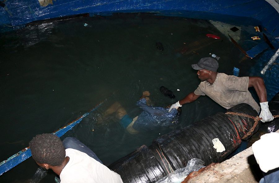 Un guardacostas libio recupera uno de los cadáveres de un migrante tras el naufragio de su embarcación frente a la ciudad de Zauara.