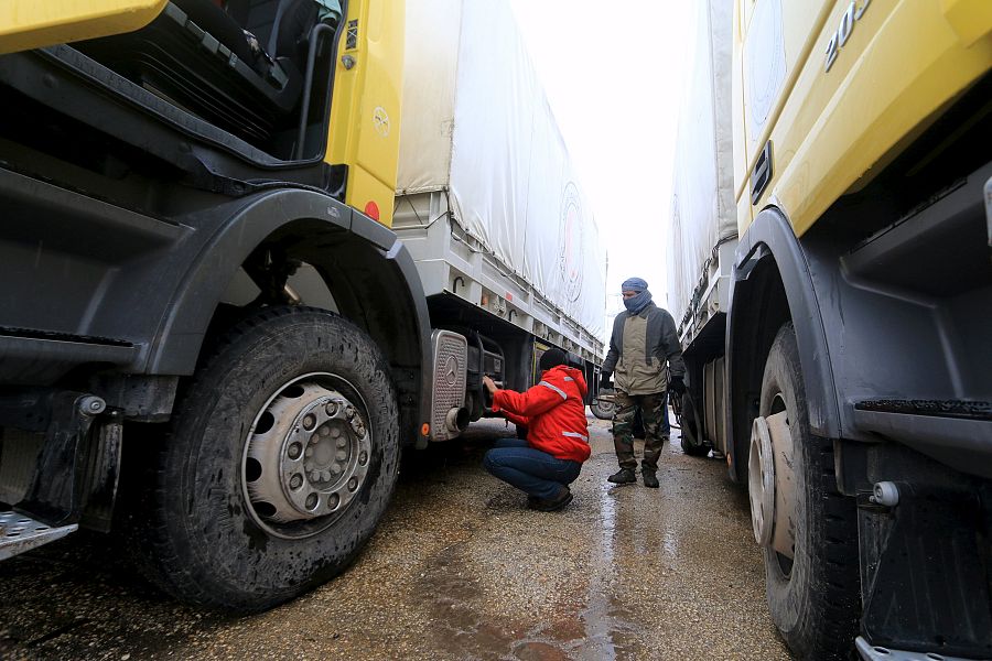 Un combatiente rebelde inspecciona el convoy de Cruz Roja de camino a Fua y Kefraya