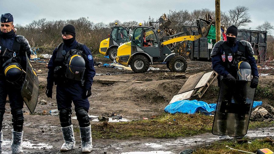 Policías antidisturbios participan en el desmontaje del campamento de migrantes conocido como "La Jungla", en Calais, norte de Francia. AFP / PHILIPPE HUGUEN