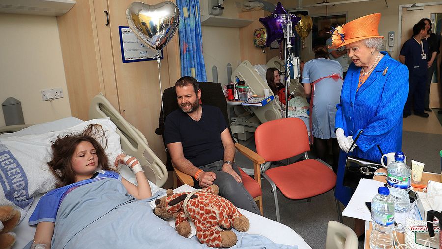 La reina Isabel II de Inglaterra habla con Evie Mills, de 14 años, y sus padres, durante su visita a los heridos del atentado de Mánchester en el Royal Manchester Children's Hospital