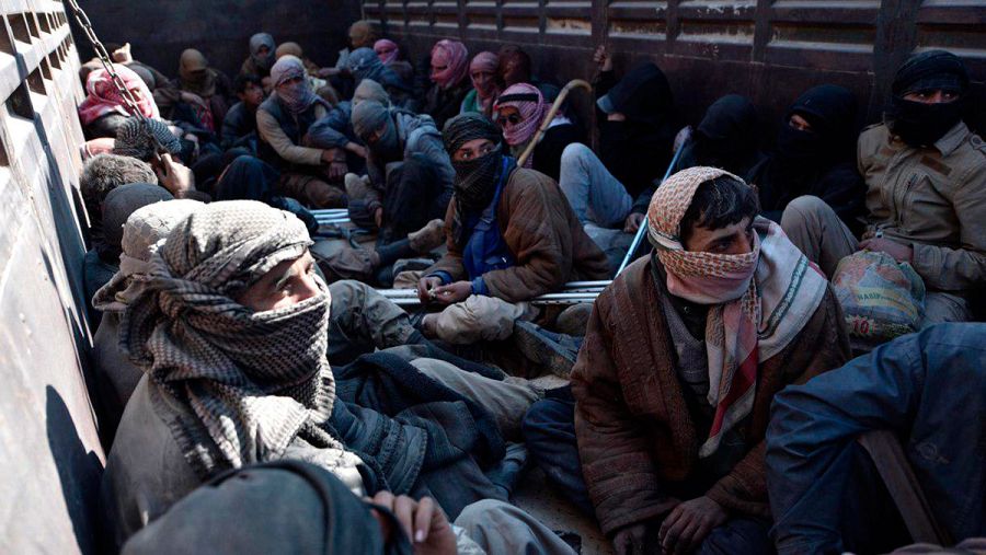 Un camión que transporta a hombres desplazados transita un camino de tierra cerca de la ciudad de Baghouz, en el norte de la provincia de Deir Ezzor, en el este de Siria
