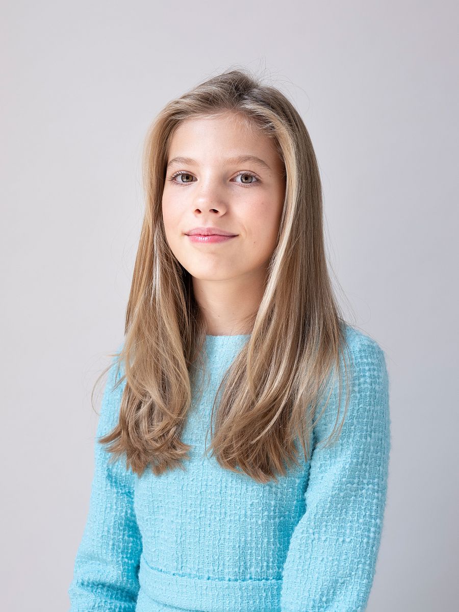 Sofía, con el cabello suelto, lleva un vestido azul celeste.