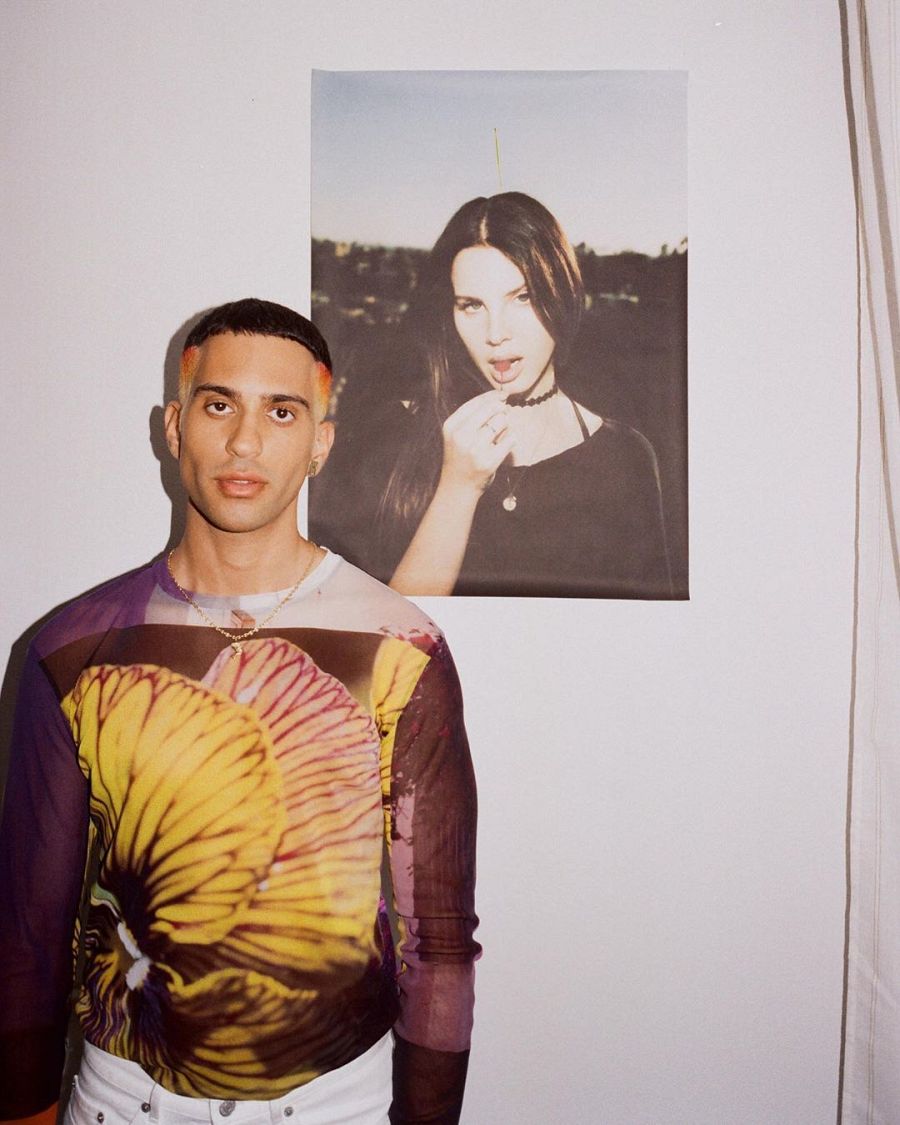 Mahmood frente a un poster de Lana del Rey en el videoclip de "Dorado"