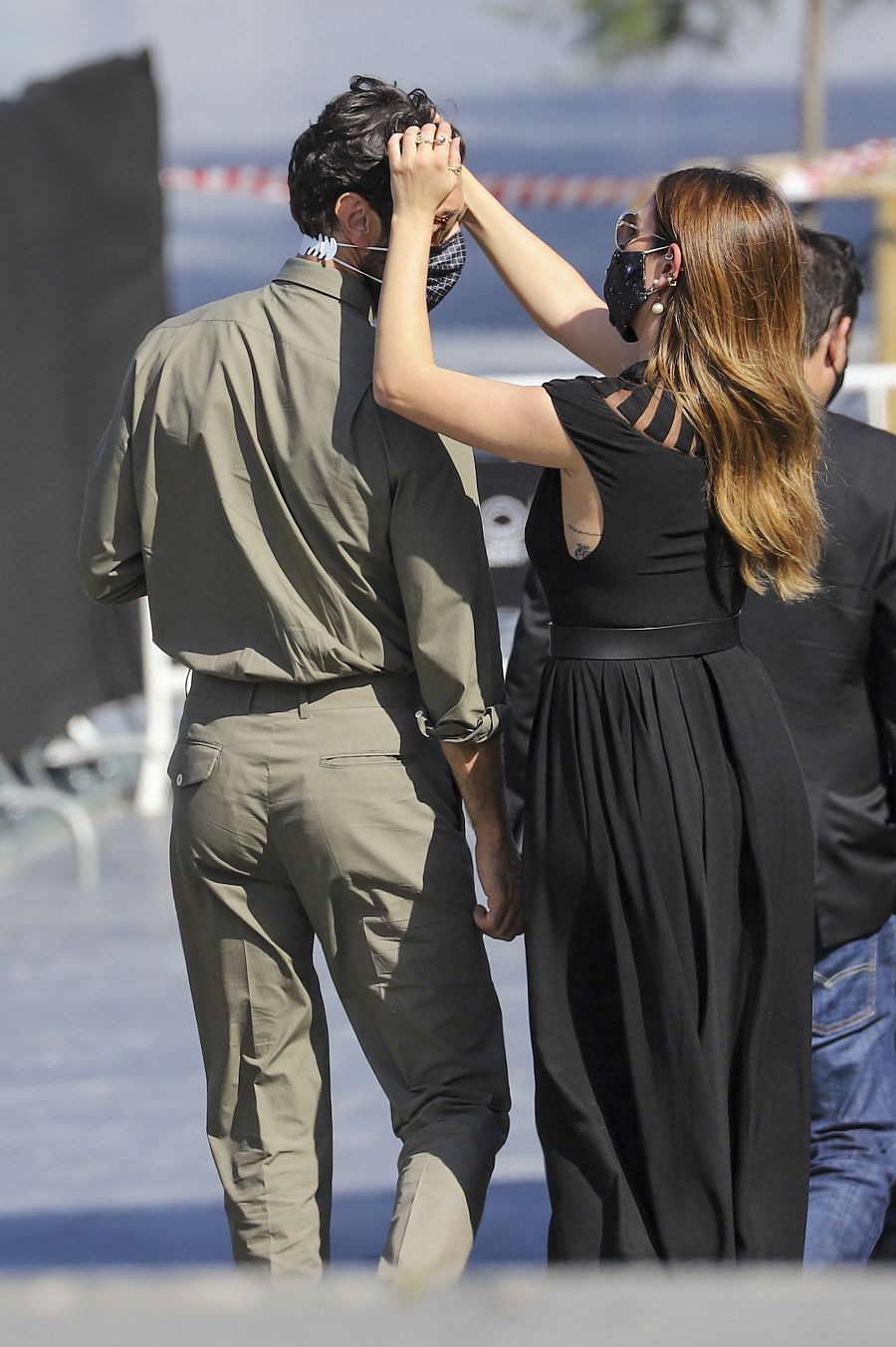 Blanca Suárez peina con las manos a Javier Rey cuando van a posar ante los medios en el Festival de San Sebastián
