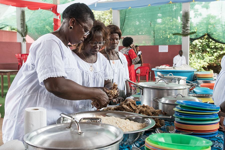 Tres mujeres guineoecuatorianas desmenuzan el pollo