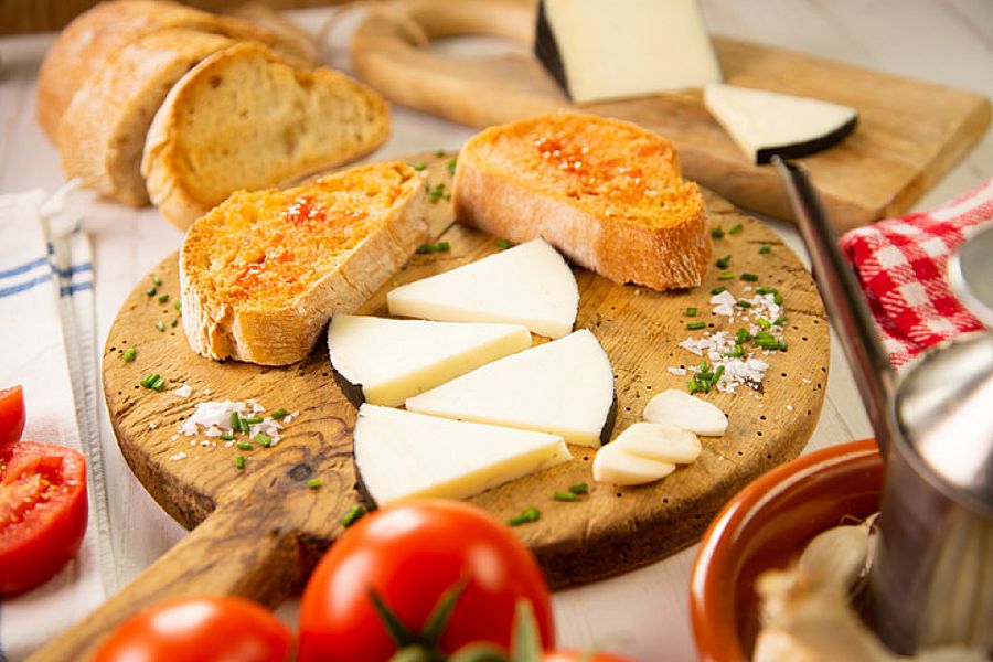 Queso manchego en lonchas acompañado de pan con tomate