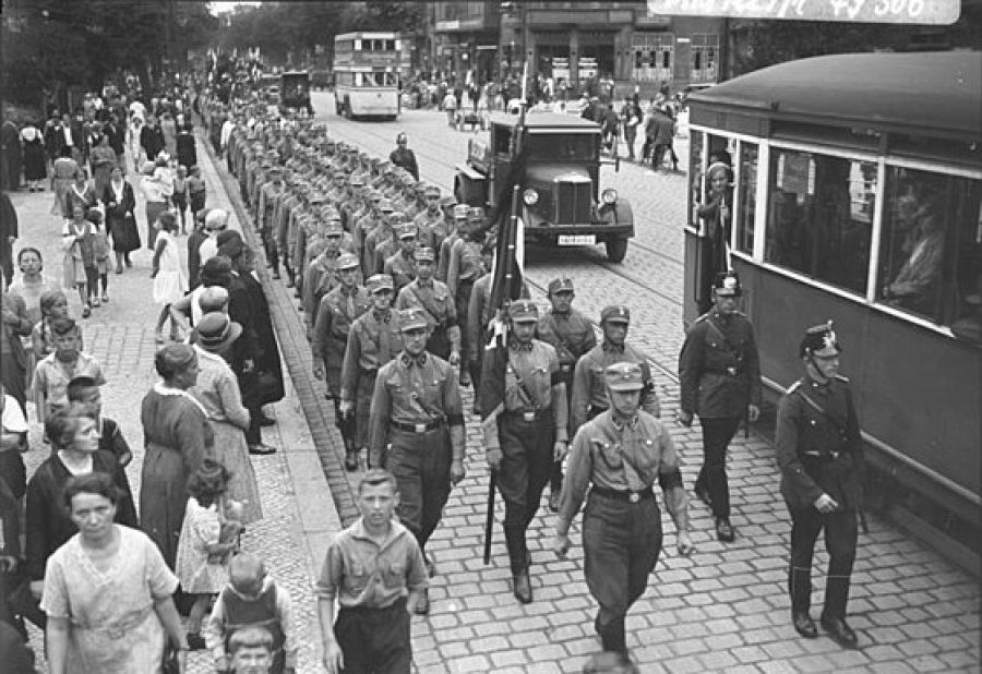 Los ciudadanos observan una larga fila de Sturmabteilung o SA desfilando por las calles de Berlín en una marcha hacia Spandau