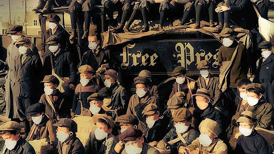 Varios niños y mayores con mascarillas en plena epidemia de la mal llamada "gripe española"