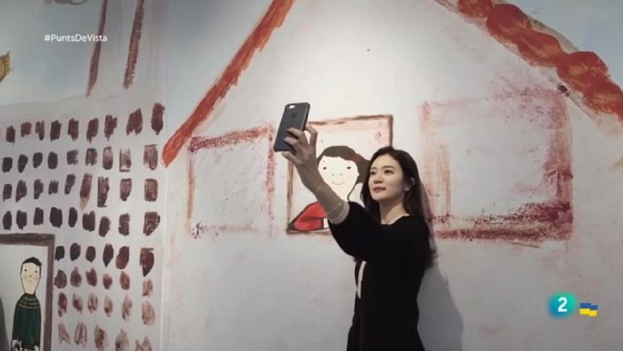 Noia coreana es fa una selfie amb una obra d'Eva Armisén