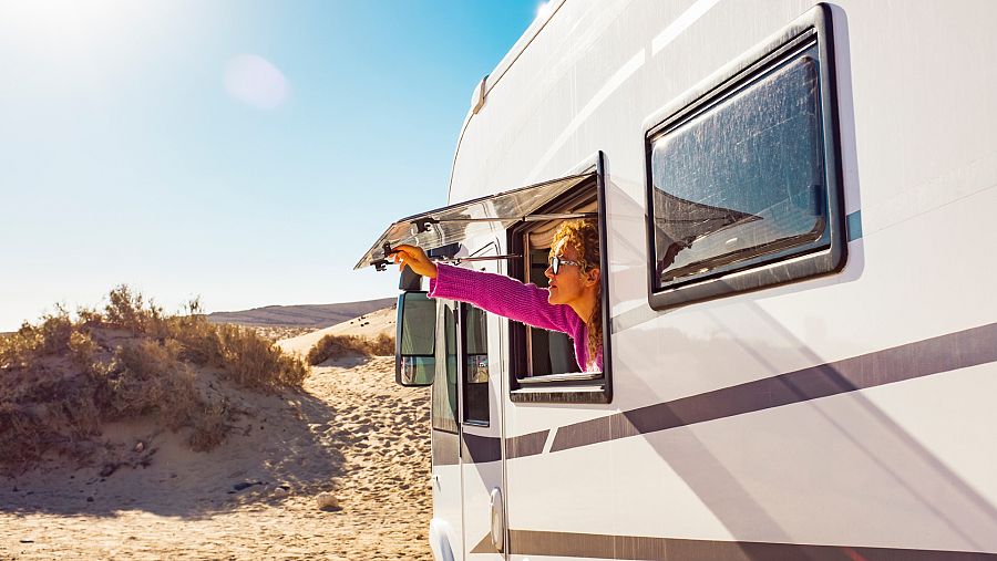 Una señora levantando la ventana de su autocaravana